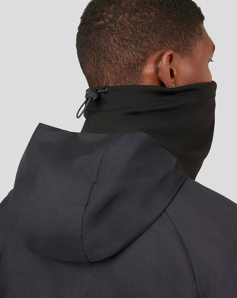 Back view of a model wearing a black Castore snood around the neck with a hooded jacket.