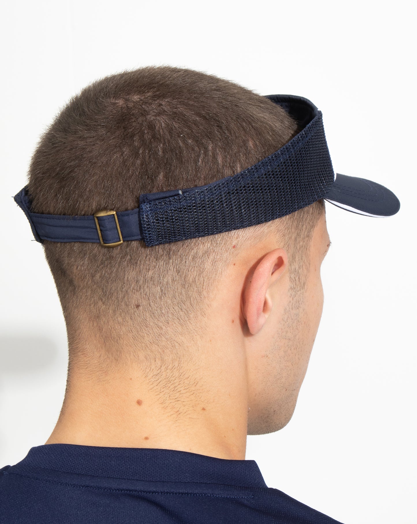 Side profile of a navy AMC Core visor worn by a person with an adjustable strap and curved brim.
