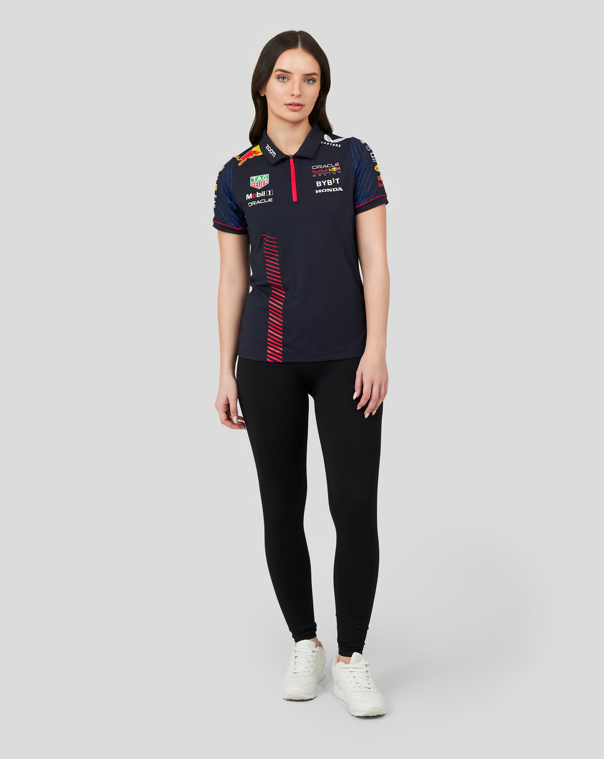 Adult female model wearing navy Oracle Red Bull Racing women's short sleeve polo with sponsor logos.