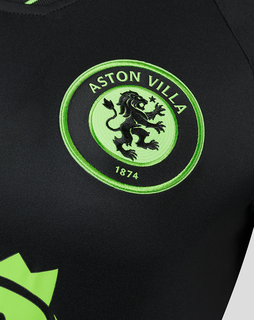 Close-up of the embroidered Aston Villa crest in lime green on a black goalkeeper shirt.