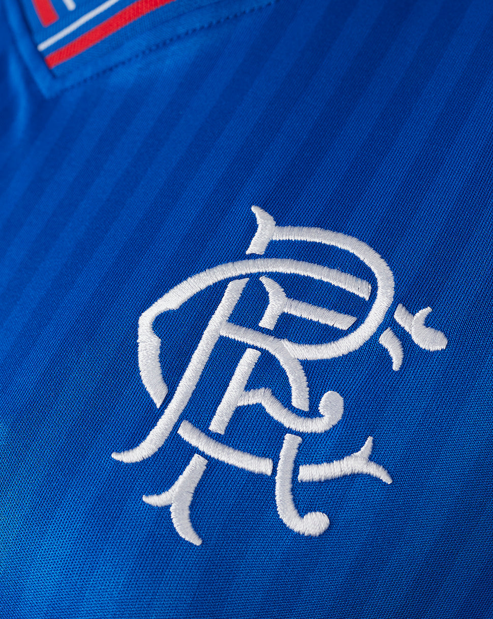 Blue Rangers home shirt close-up showing white embroidered crest and striped ribbed collar.