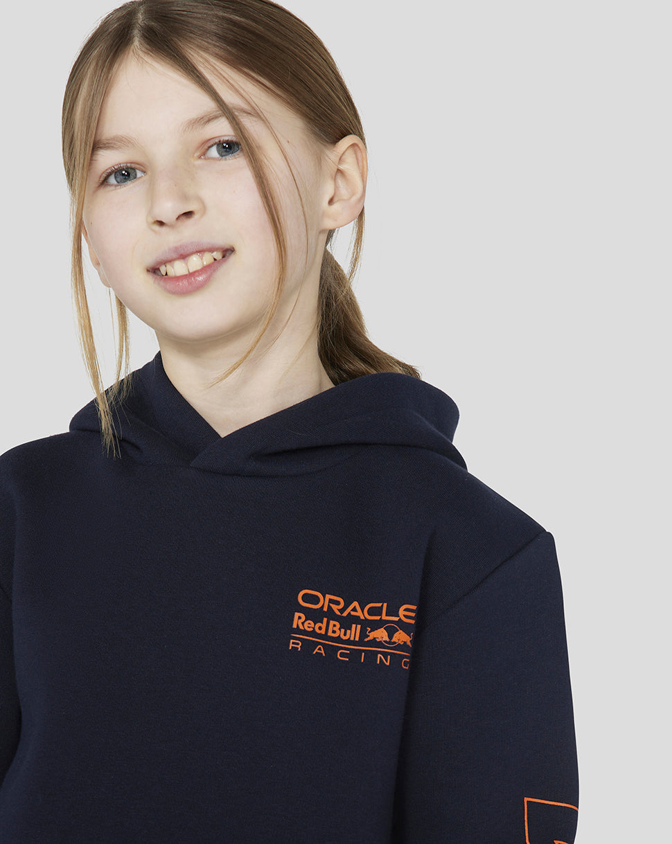 Girl wearing a navy Oracle Red Bull Racing hoodie with an orange logo on the chest.