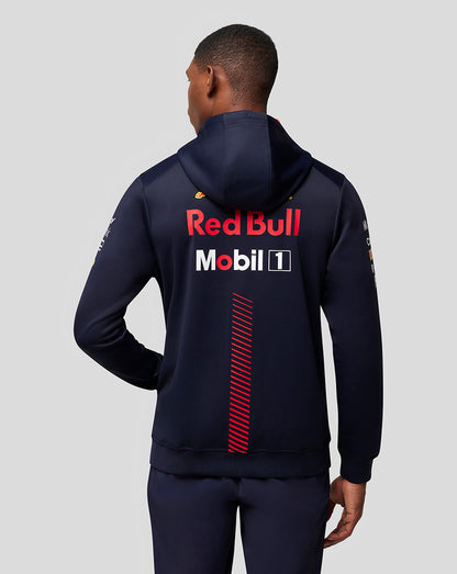 Back view of a man wearing a navy Oracle Red Bull Racing hoodie with Red Bull and Mobil 1 logos and a red diagonal stripe down the back.