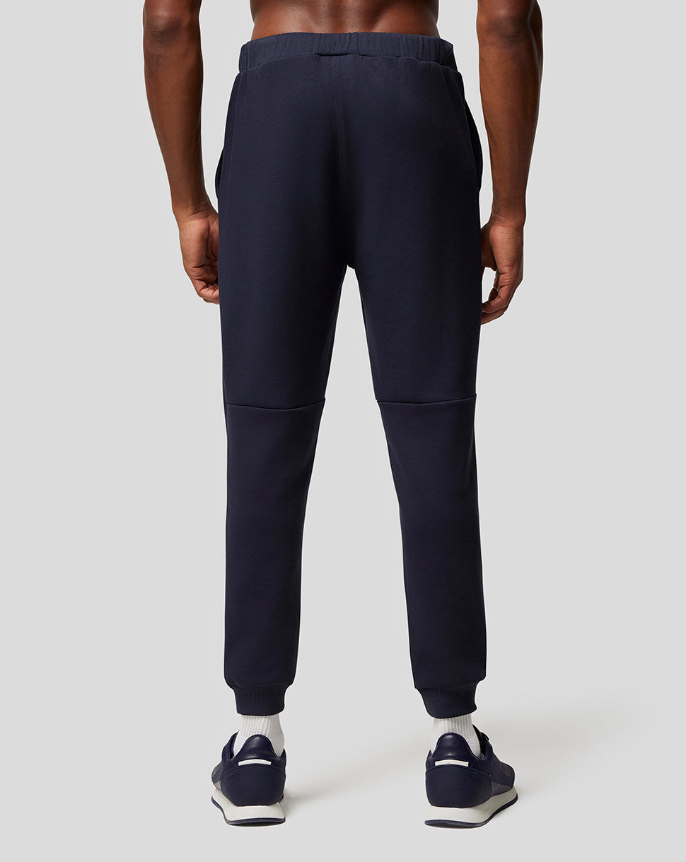 Rear view of navy lifestyle pant with logo on the left thigh and ribbed cuffs
