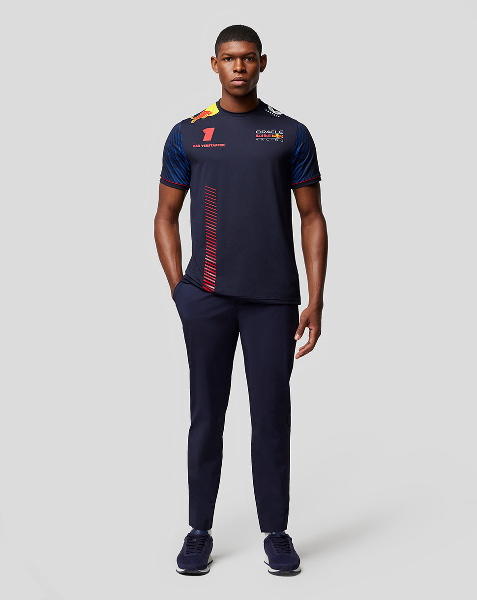 Full body back view of a man in a navy Red Bull Racing T shirt featuring a red diagonal stripe panel down the back