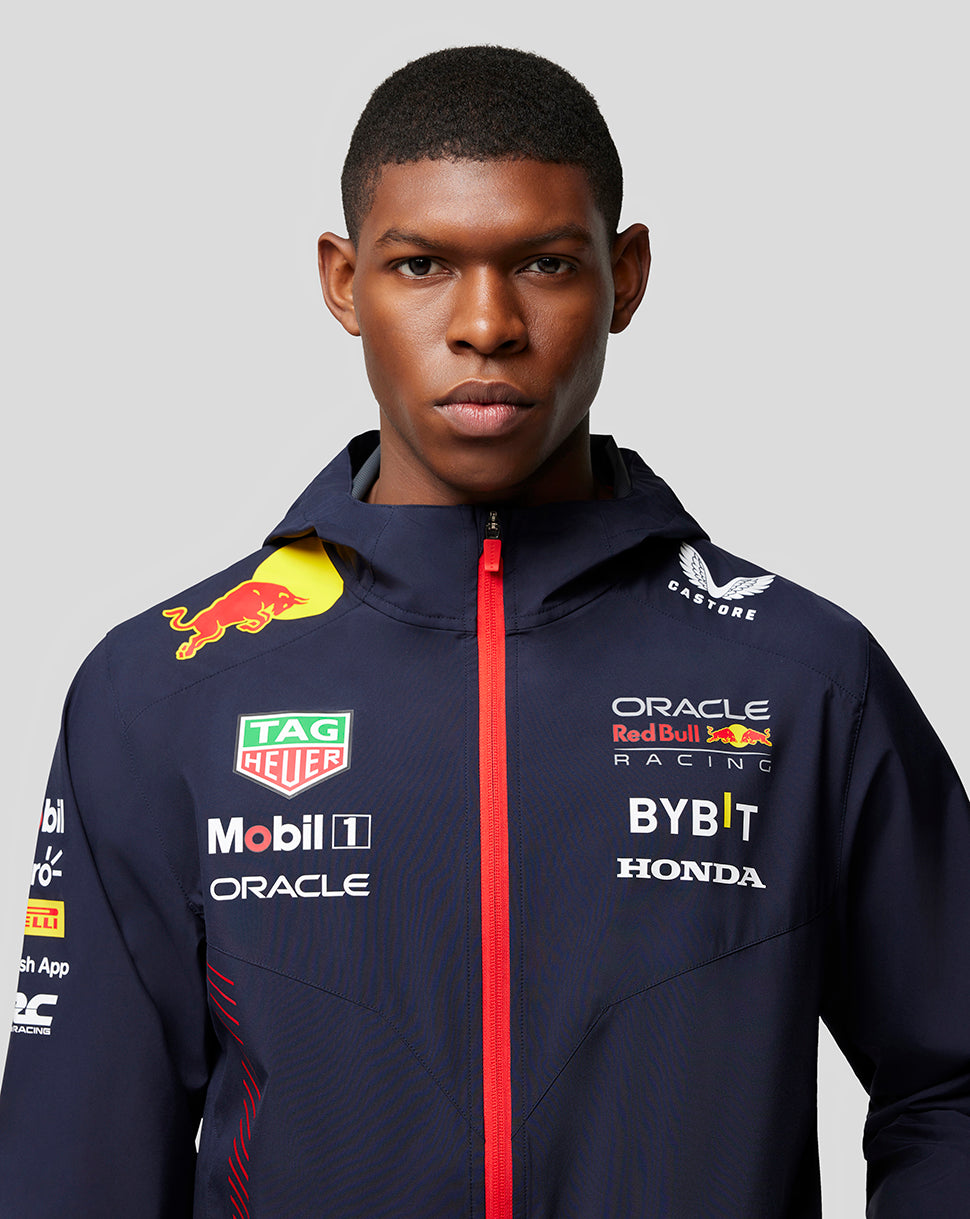 Male model wearing navy water resistant Oracle Red Bull Racing jacket with red zipper and sponsor logos on the chest