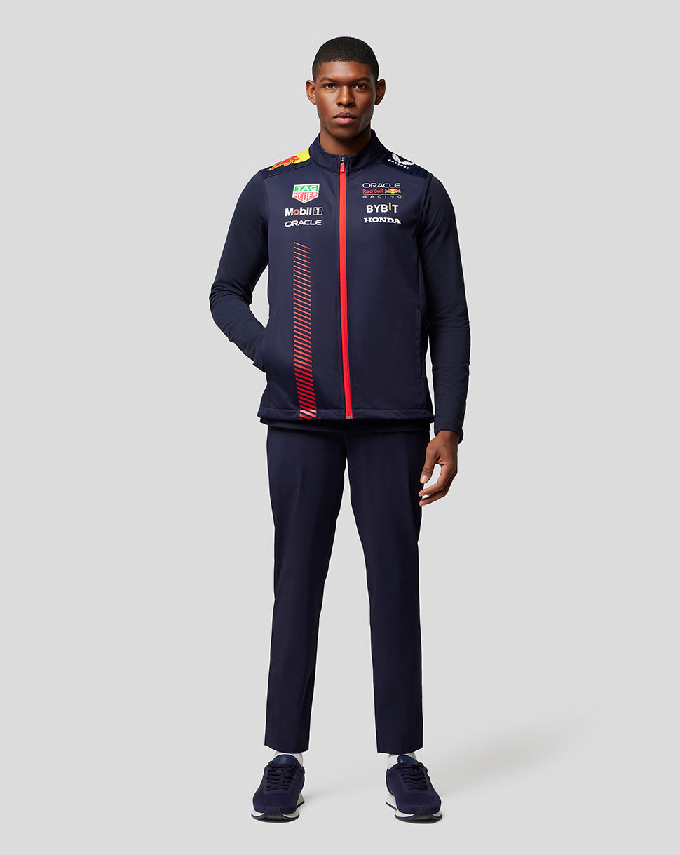 Male model wearing a navy Oracle Red Bull Racing Replica Hybrid Gilet with red front zipper and sponsor logos