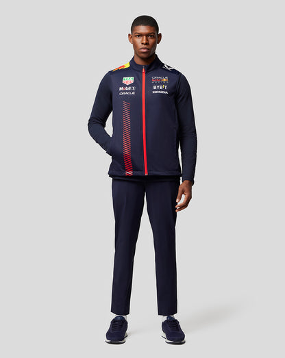 Male model wearing a navy Oracle Red Bull Racing Replica Hybrid Gilet with red front zipper and sponsor logos