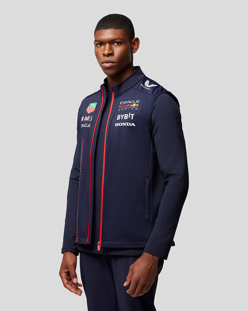 Male model wearing navy Oracle Red Bull Racing Replica Hybrid Gilet with red zipper and sponsor logos.