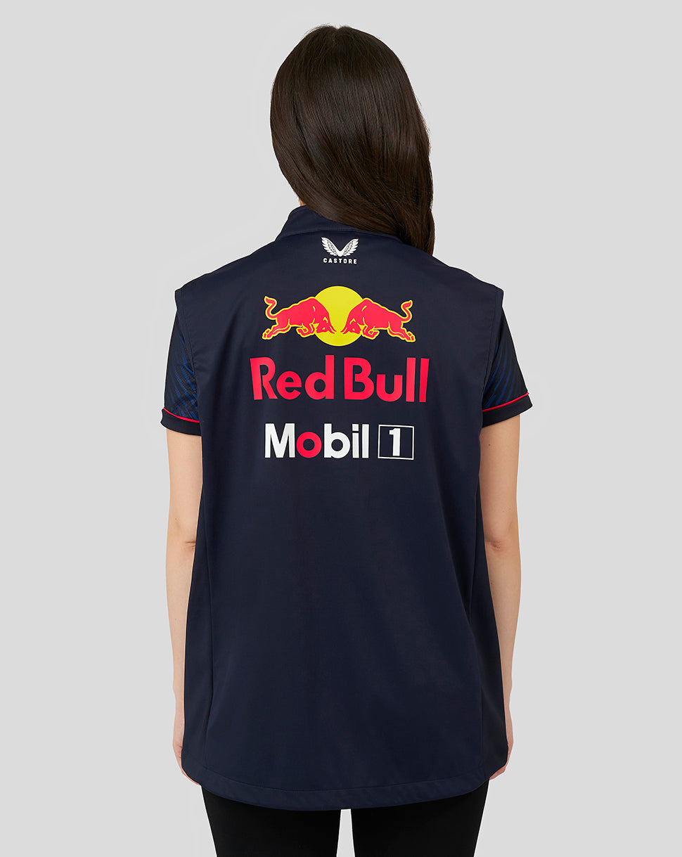 Back view of a woman in a navy Red Bull Racing jacket with large sponsor logo on the back