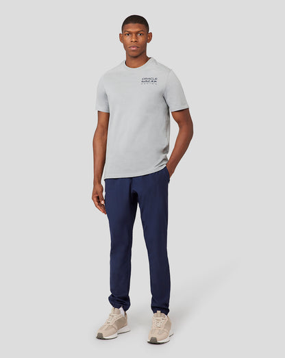 Model in grey Oracle Red Bull Racing Core T-Shirt with a small chest logo, paired with navy pants and beige sneakers