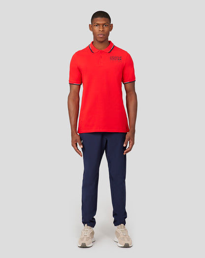 Front view of a male model wearing flame scarlet Core Polo with chest logo and navy rib trim.