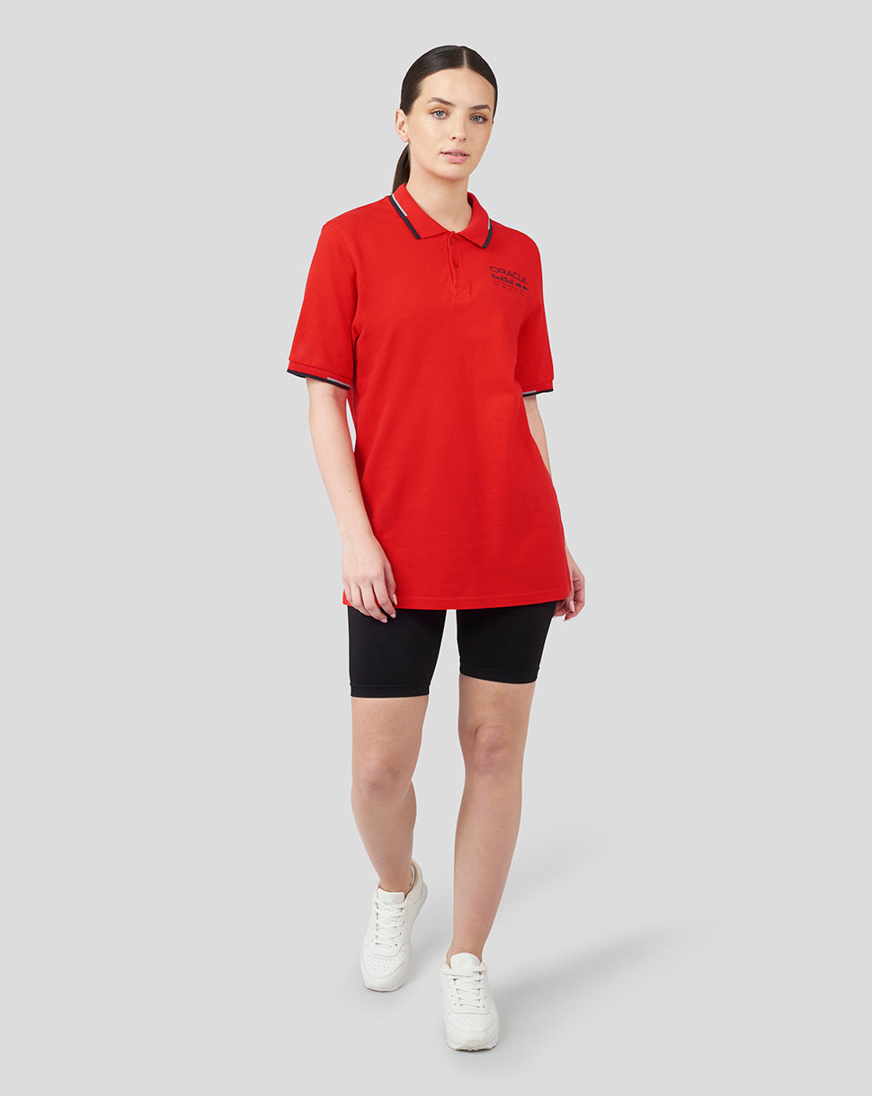 Female model wearing flame scarlet Oracle Red Bull Racing Core Polo with navy tipped collar and cuffs