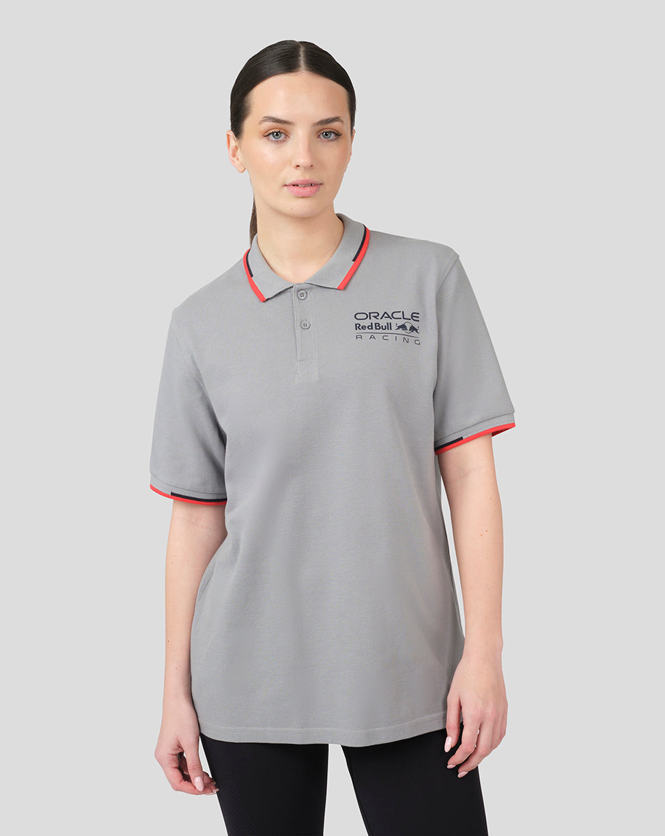 Model wearing grey Oracle Red Bull Racing Core Polo with red trim on collar and cuffs and chest logo