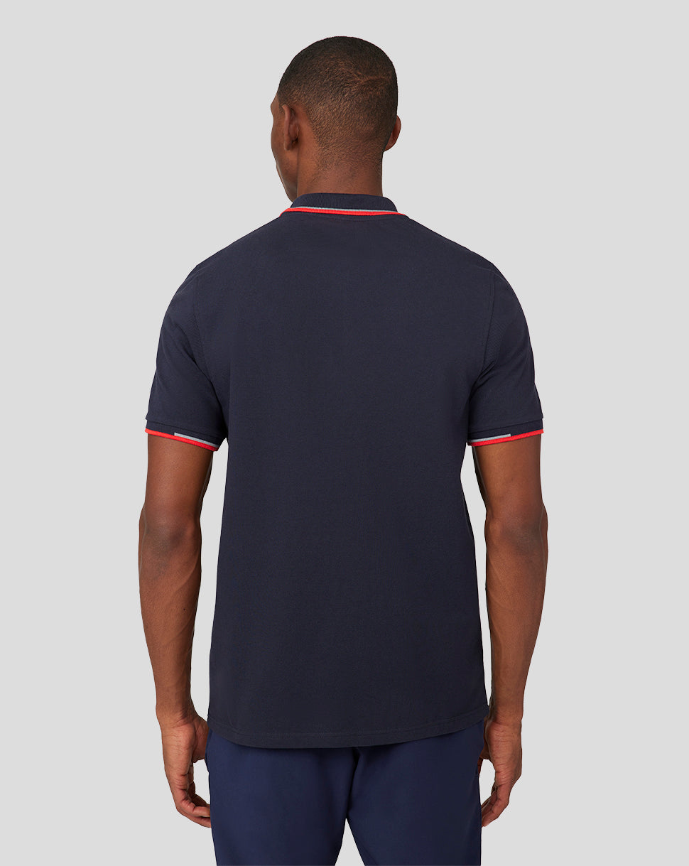 Back view of a man in a navy Oracle Red Bull Racing Core Polo with red trim on collar and sleeves