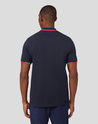 Back view of a man in a navy Oracle Red Bull Racing Core Polo with red trim on collar and sleeves