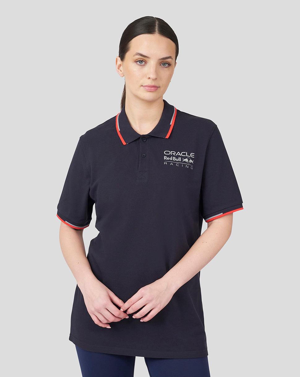 Model wearing navy Oracle Red Bull Racing Core Polo with red piping on collar and sleeve cuffs and chest logo