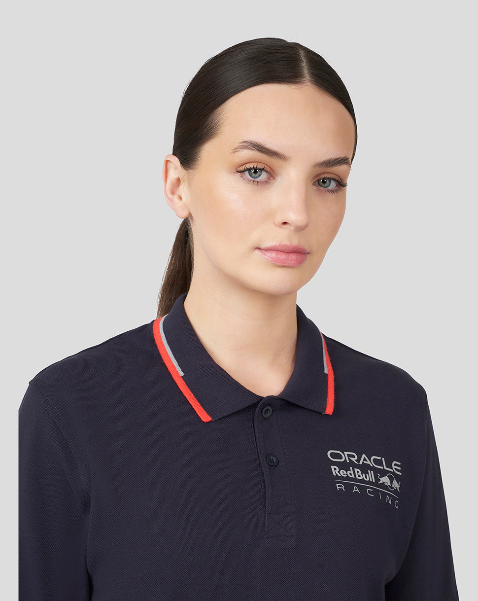Torso shot of a woman in navy Night Sky Oracle Red Bull Racing Core Polo with chest logo and red tipping on the collar.