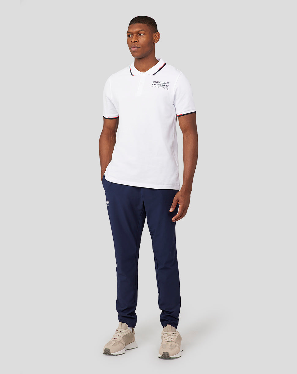 Male model wearing white Oracle Red Bull Racing Core Polo with chest logo and navy trim on collar and sleeves