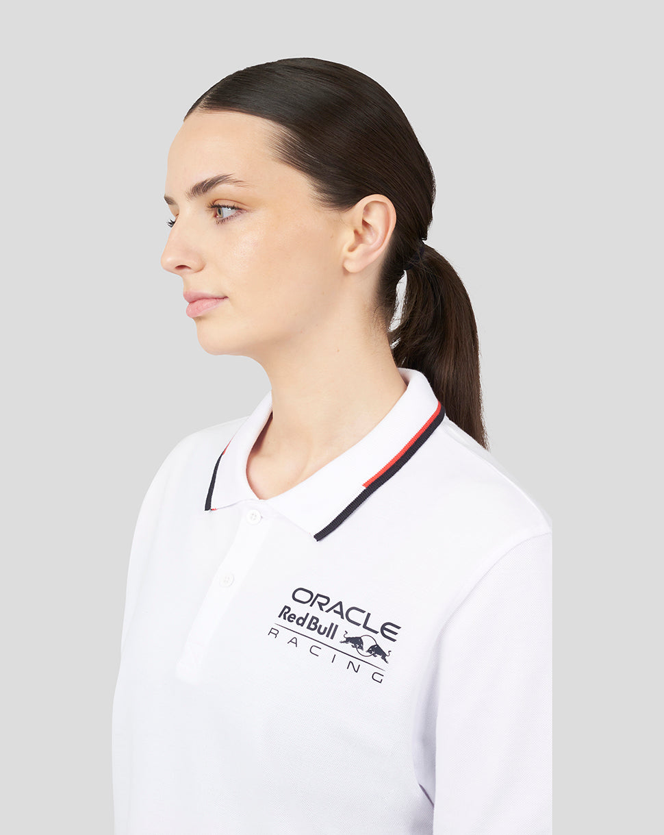 Three quarter front view of white Oracle Red Bull Racing polo showing chest logo and navy red tipped collar.