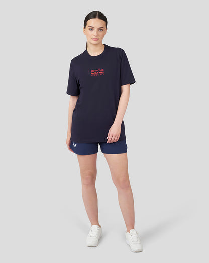 Woman wearing navy Oracle Red Bull Racing T shirt with front logo, blue shorts and white sneakers