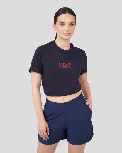 Front view of a woman in a navy cropped Oracle Red Bull Racing T shirt with a red logo and navy shorts.