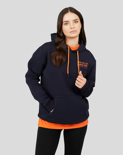 Woman wearing navy Oracle Red Bull Racing hoodie with orange drawstrings and chest logo, layered orange shirt underneath.