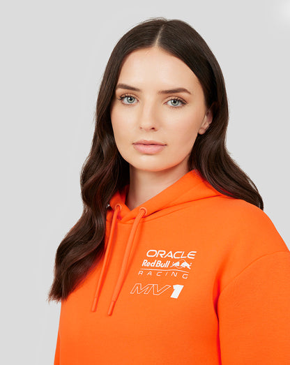 Close-up of a woman wearing an exotic orange Oracle Red Bull Racing hoodie with a chest logo.