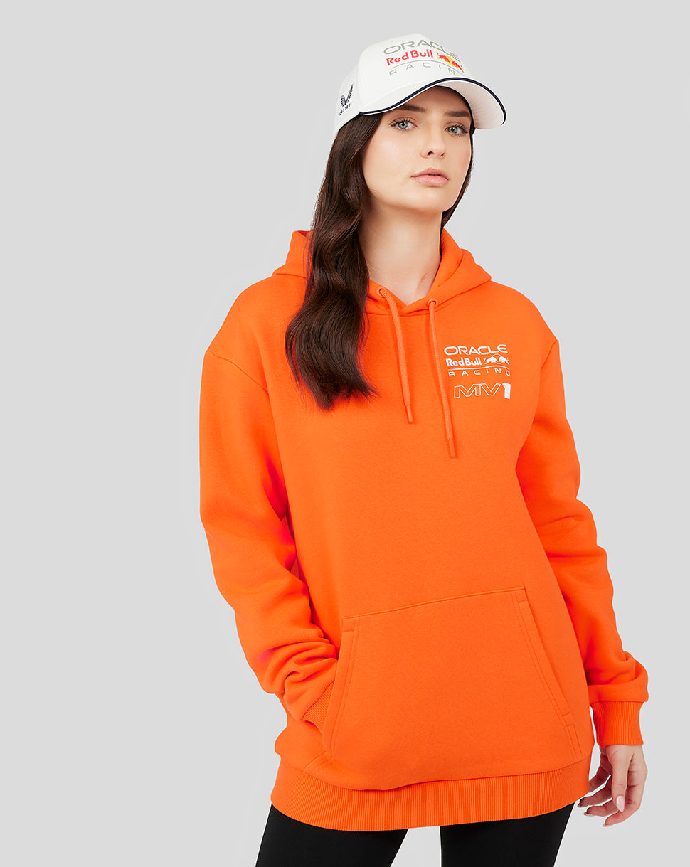 Model wearing a bright orange Oracle Red Bull Racing hoodie with a logo on the chest