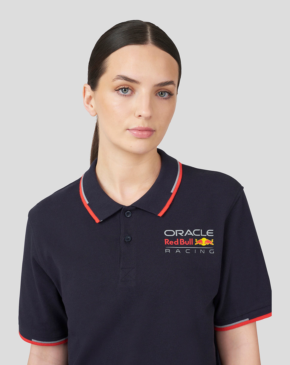 Female model wearing navy Oracle Red Bull Racing polo with left chest logo and red tipped collar