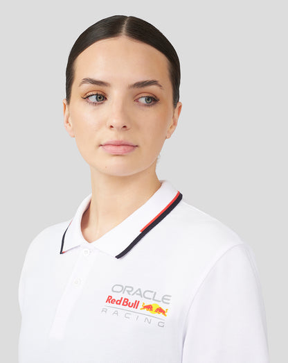 Front view of a woman wearing a white Oracle Red Bull Racing polo with chest logo and contrast tipped collar