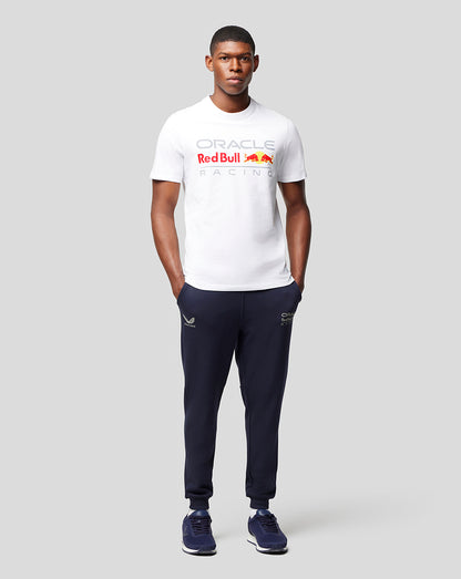 Male model wearing white Oracle Red Bull Racing front logo T shirt paired with navy joggers and blue sneakers.