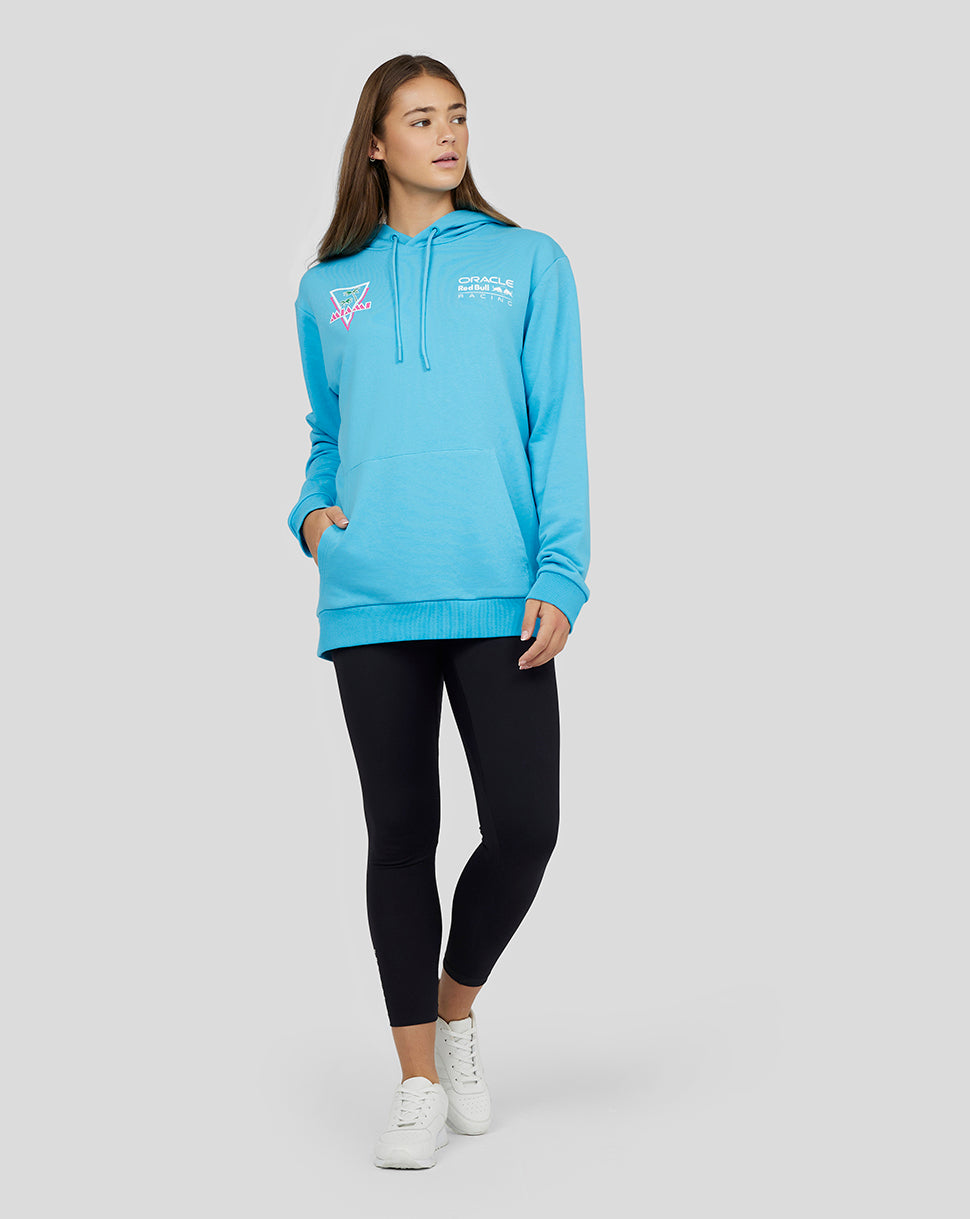 Woman in light blue Oracle Red Bull Racing Miami hoodie with a drawstring hood and front logo.